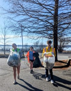 Students at outdoor cleanup with trash bags