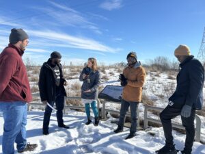 5 young men standing on snow and in a semi circle