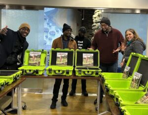 5 young men and female tour guide with lime green laptops